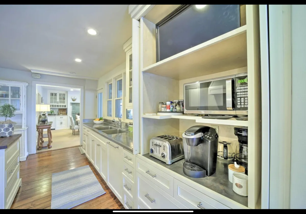 This image shows a well-equipped kitchen with ample cabinet storage, modern appliances, and generous counter space. The setup is efficient and inviting, suitable for both everyday meals and special gatherings. The warm lighting and organized layout give the space a welcoming, independent feel.